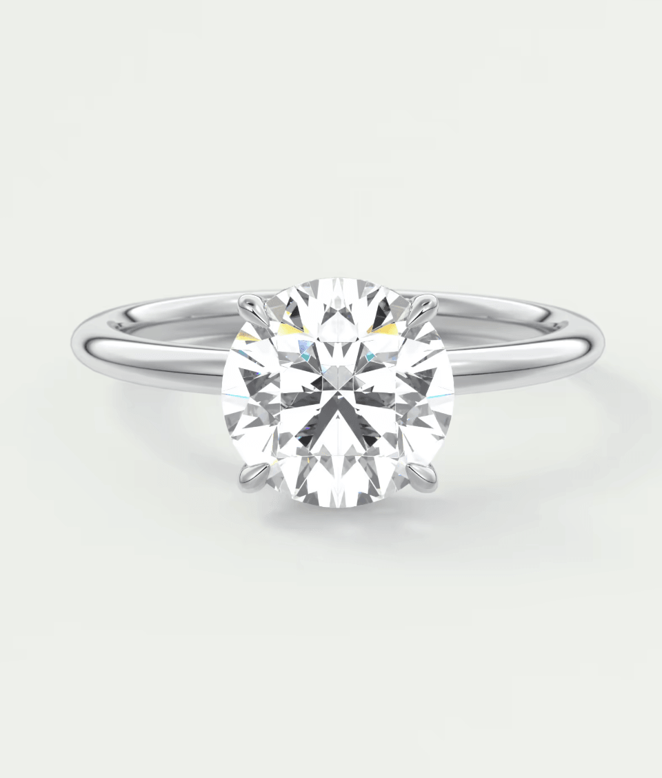 18-karat white gold solitaire diamond engagement ring with a cushion-cut center stone.