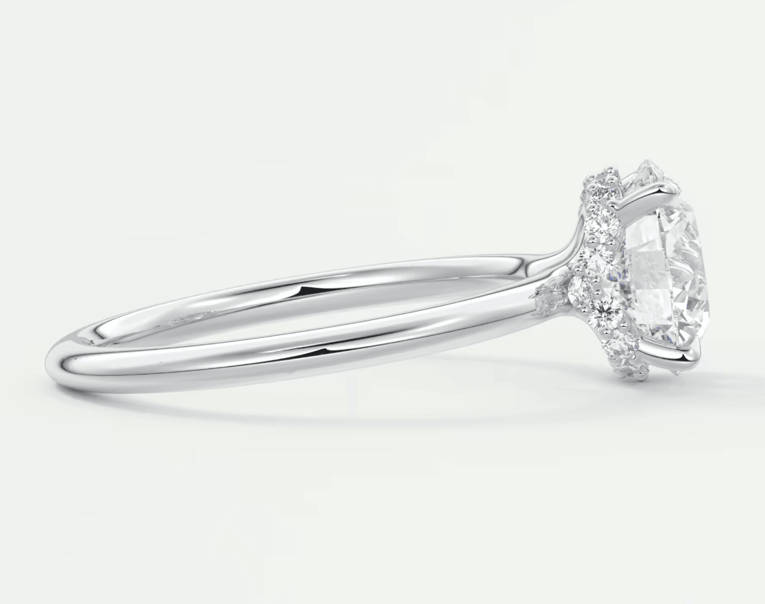 18k white gold engagement ring with a marquise-cut diamond and halo of smaller diamonds.