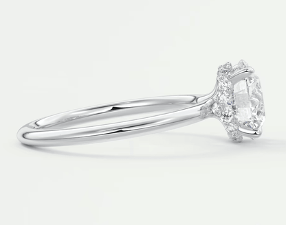 18k white gold engagement ring with a marquise-cut diamond and halo of smaller diamonds.