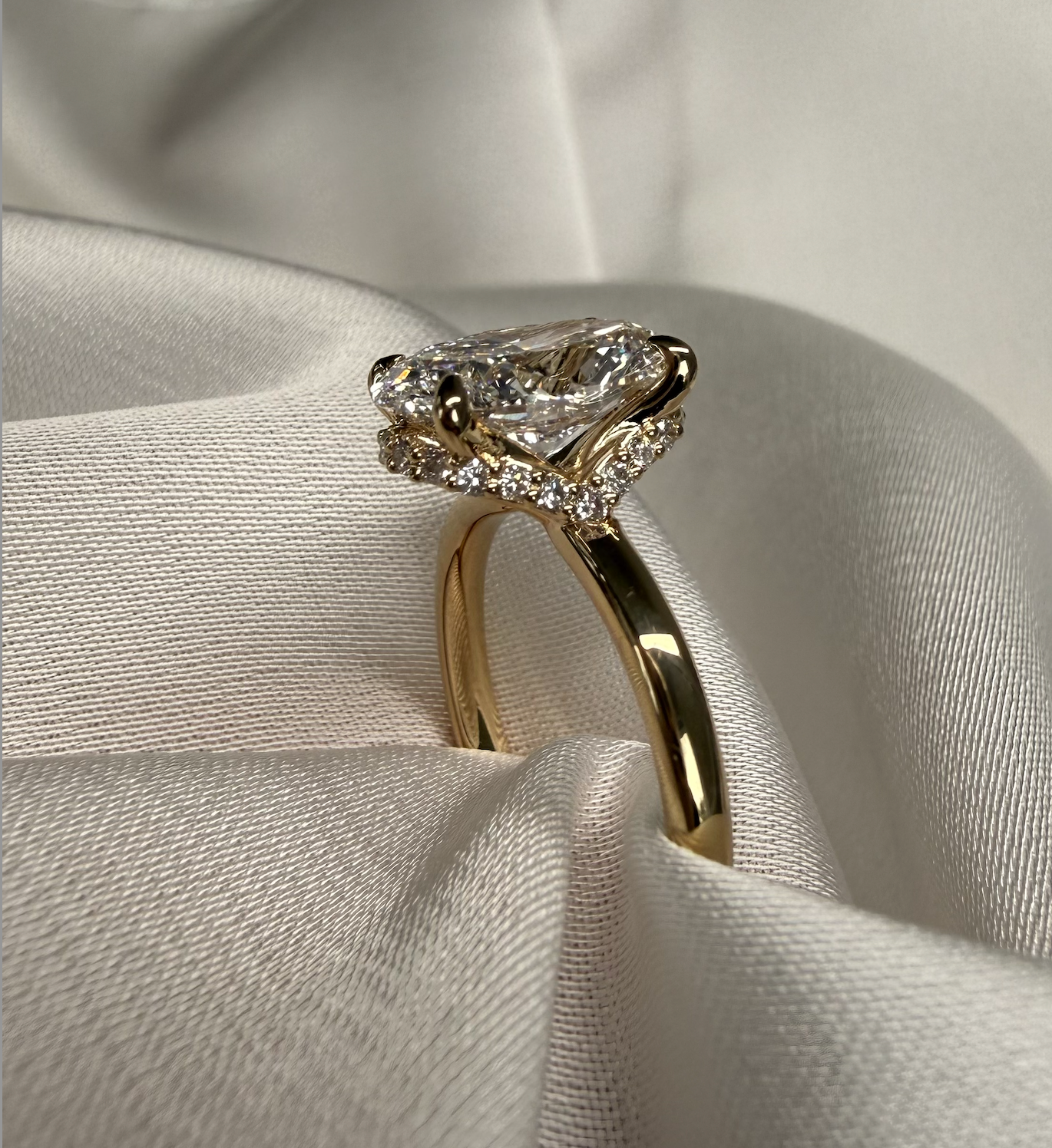 Gold ring with a diamond on a light fabric background