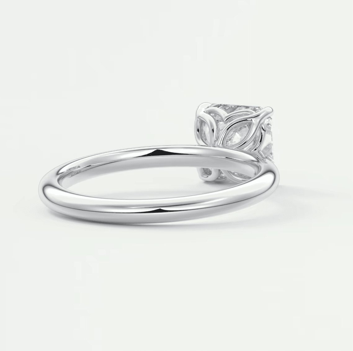 White diamond engagement ring with leaf design on band, platinum or silver material.