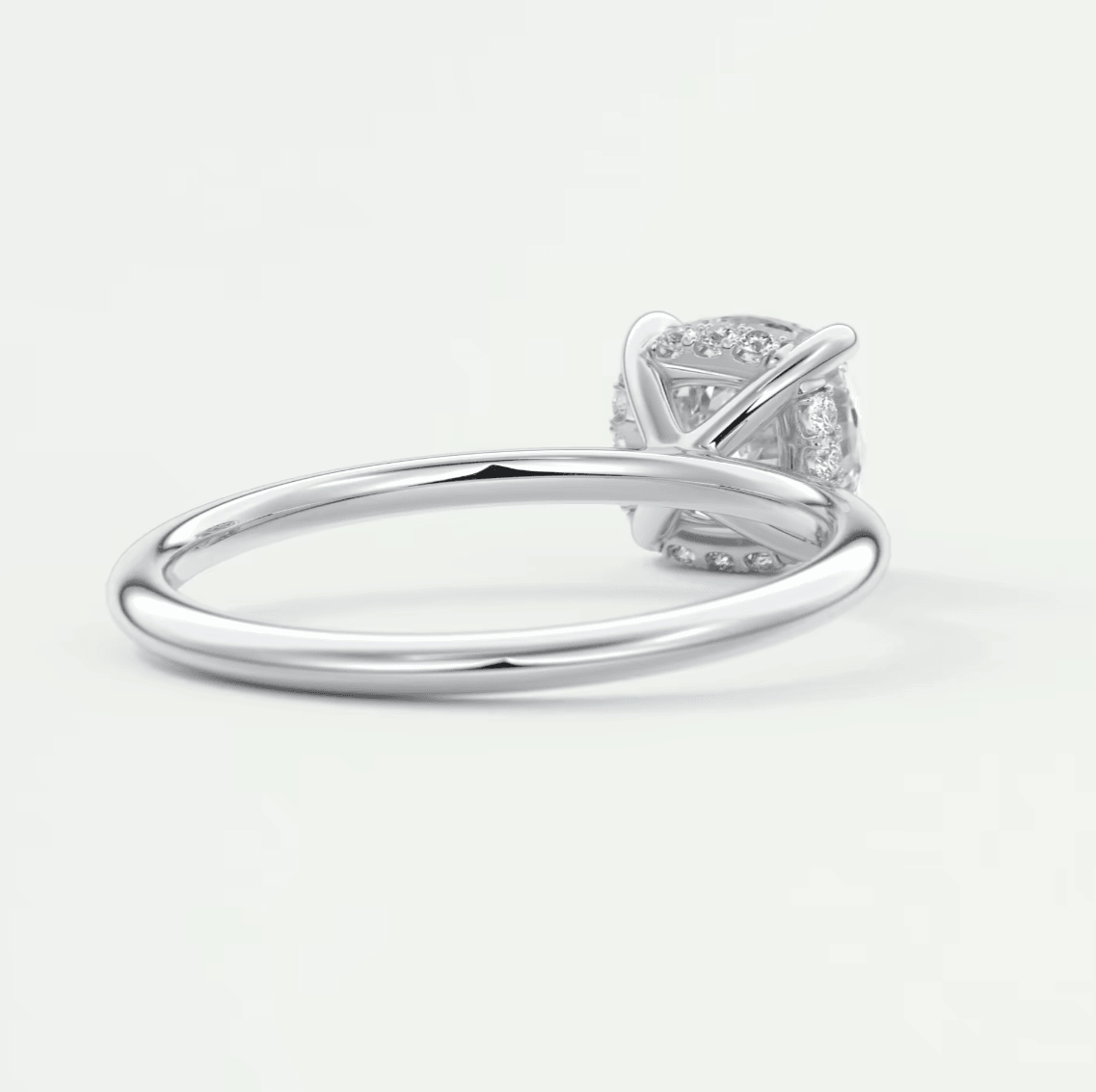 White gold diamond engagement ring with a cushion-cut center stone and intricate band design.