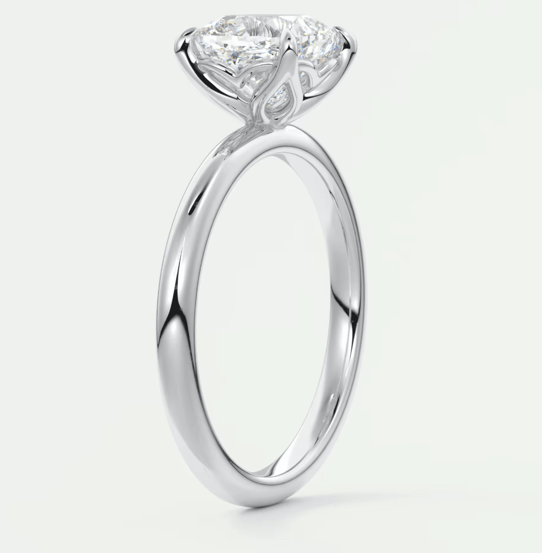 18-karat white gold engagement ring with a cushion-cut diamond.