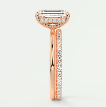 18k rose gold diamond engagement ring with an emerald cut center stone and channel set diamonds on the band.