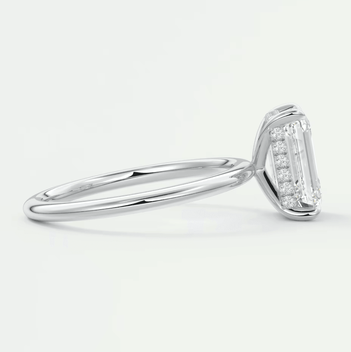 18k white gold emerald cut diamond engagement ring with a halo of smaller diamonds.