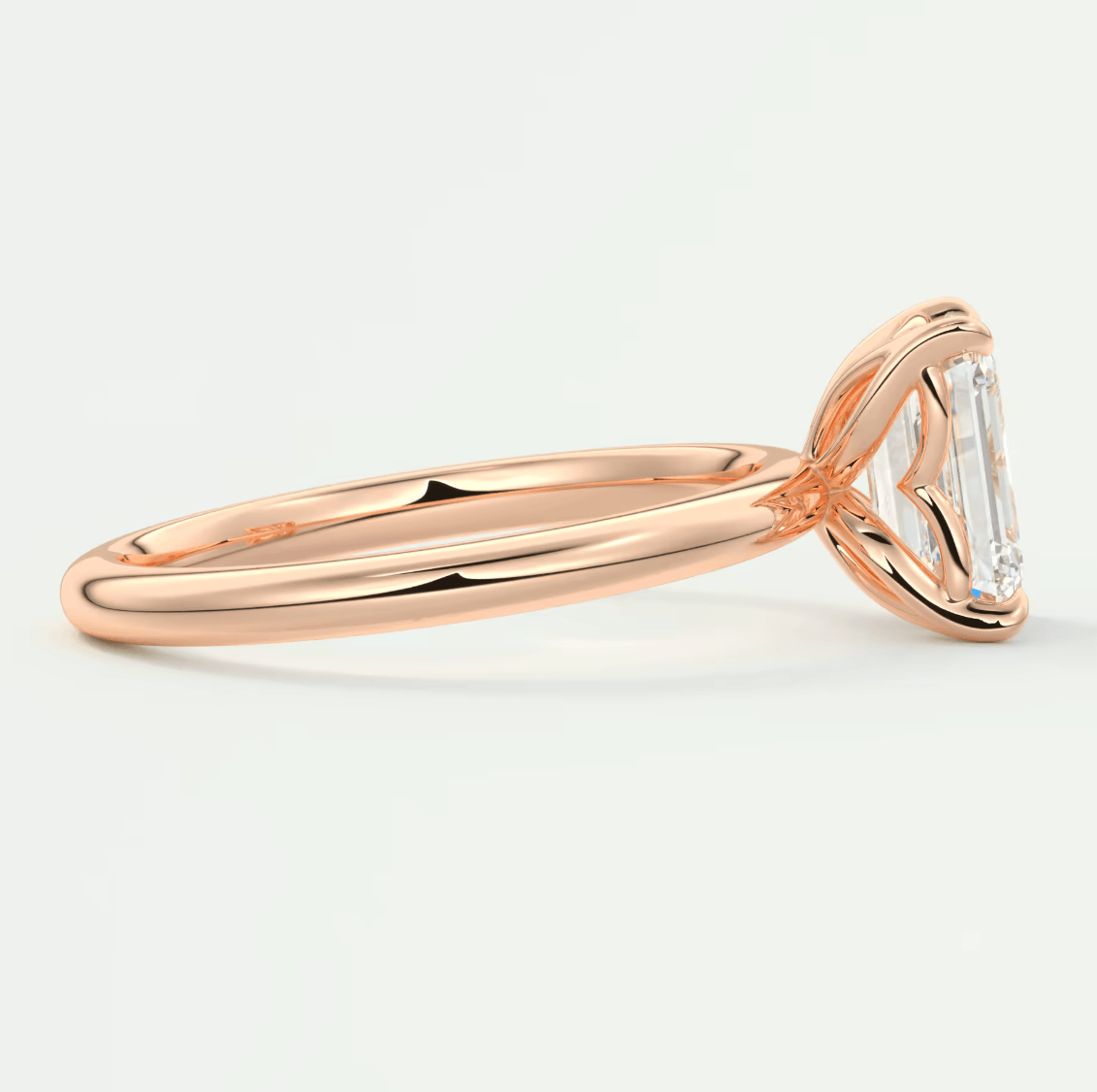 18-karat rose gold engagement ring with an emerald-cut diamond.