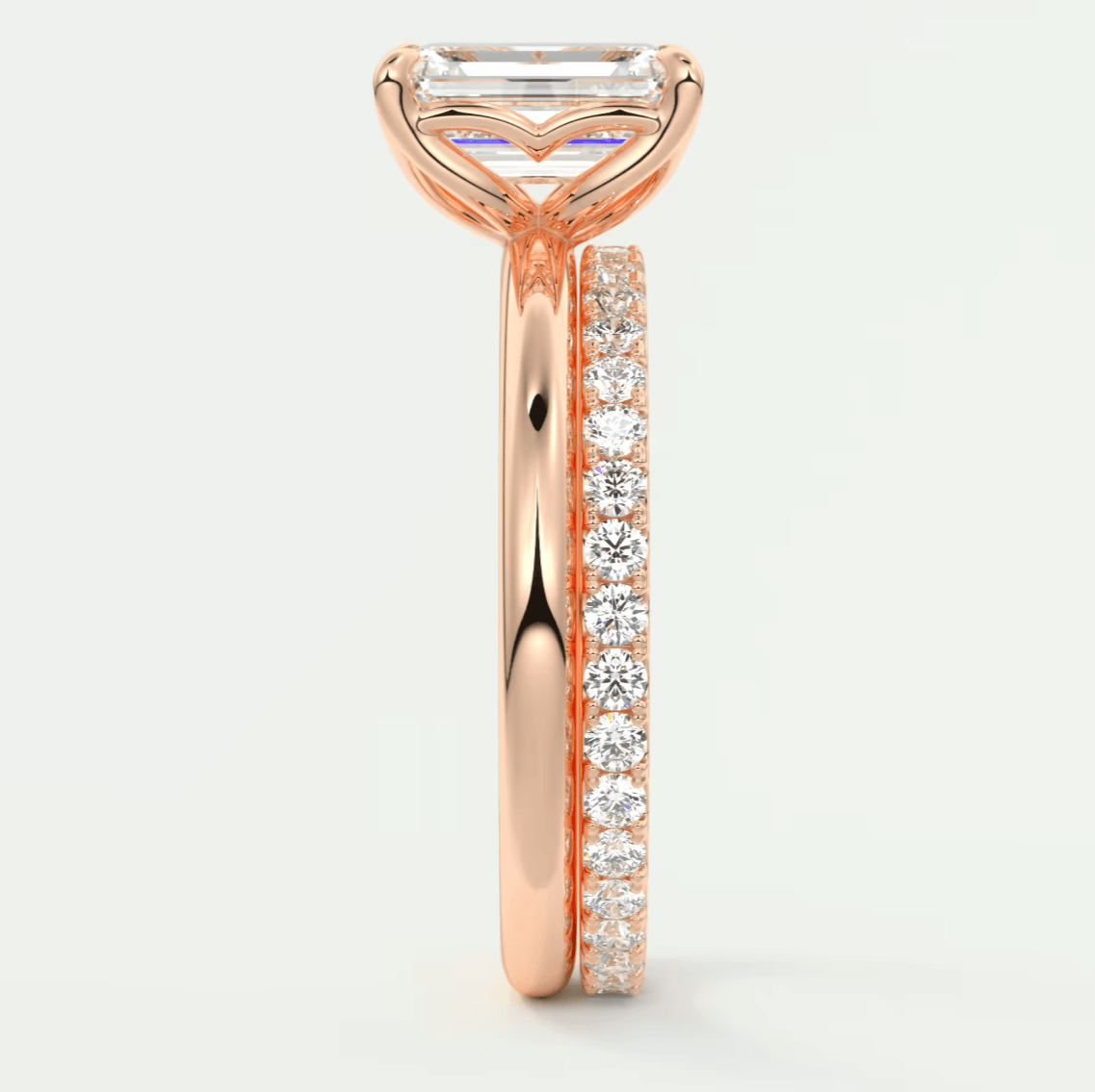18k rose gold engagement ring with emerald cut diamond and pavé side stones.