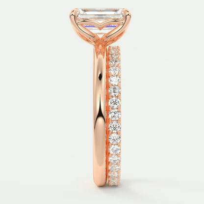 18k rose gold engagement ring with emerald cut diamond and pavé side stones.