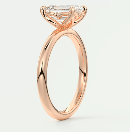 18-karat rose gold engagement ring with a marquise-cut diamond and small diamonds on the band.