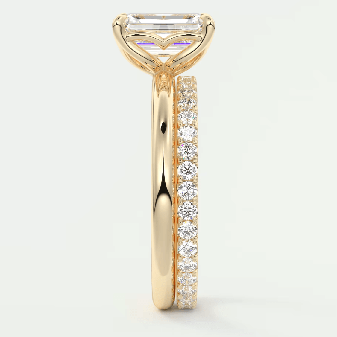 18k yellow gold engagement ring with an emerald-cut diamond and a pave set band.