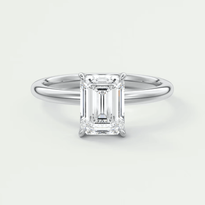 18-karat white gold emerald-cut diamond engagement ring.