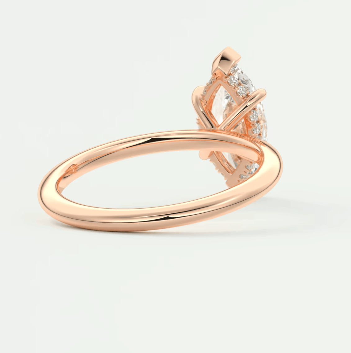 18-karat rose gold diamond engagement ring with a marquise-cut center stone and pavé-set diamonds on the band.