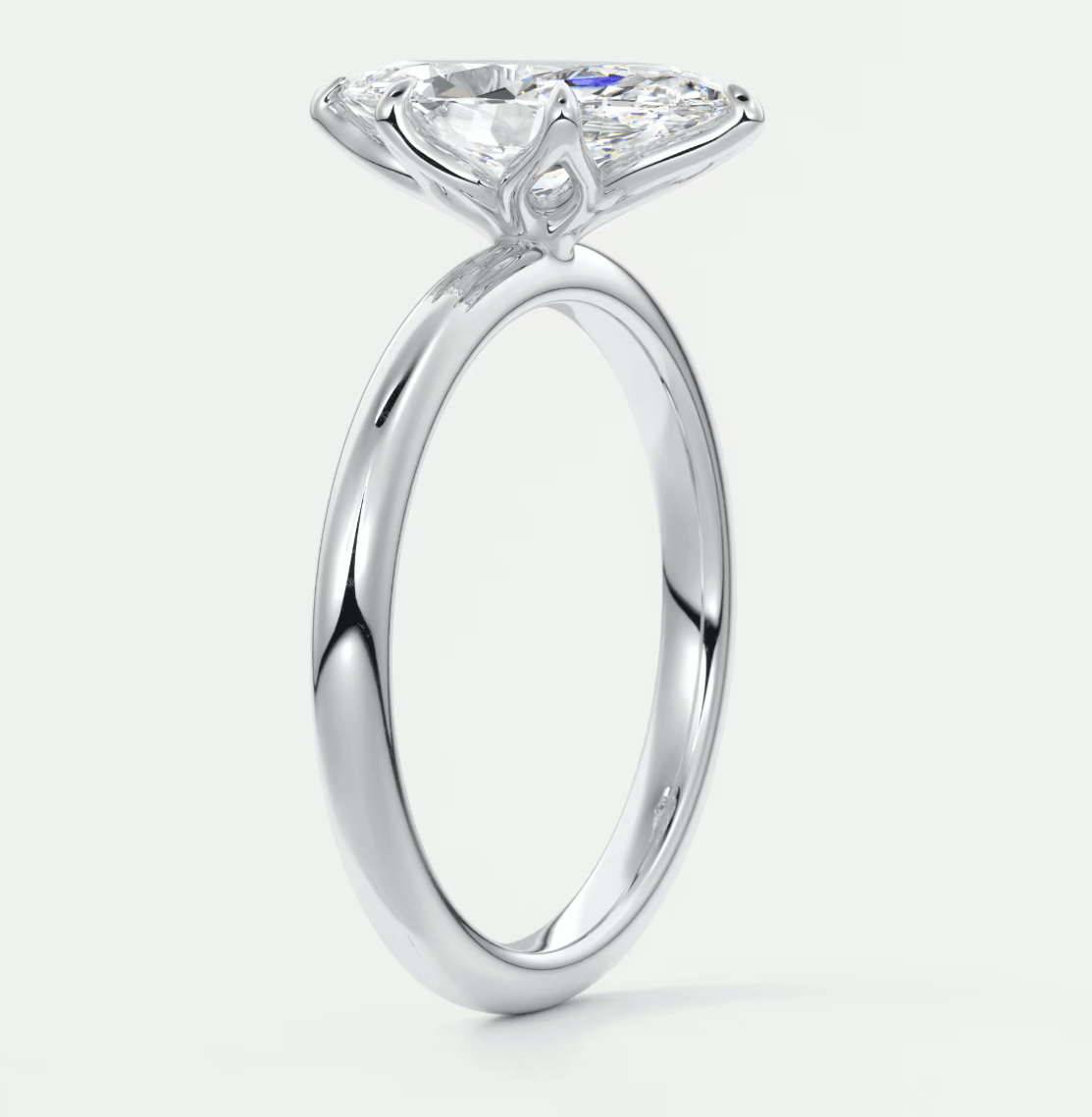 White gold engagement ring with a pear-shaped diamond and small diamonds on the band.