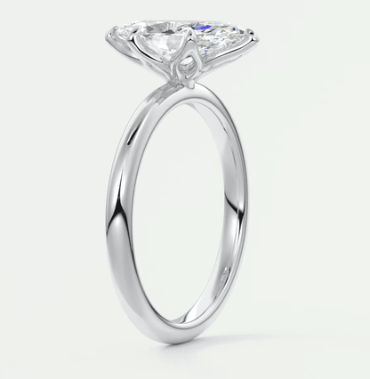 White gold engagement ring with a pear-shaped diamond and small diamonds on the band.