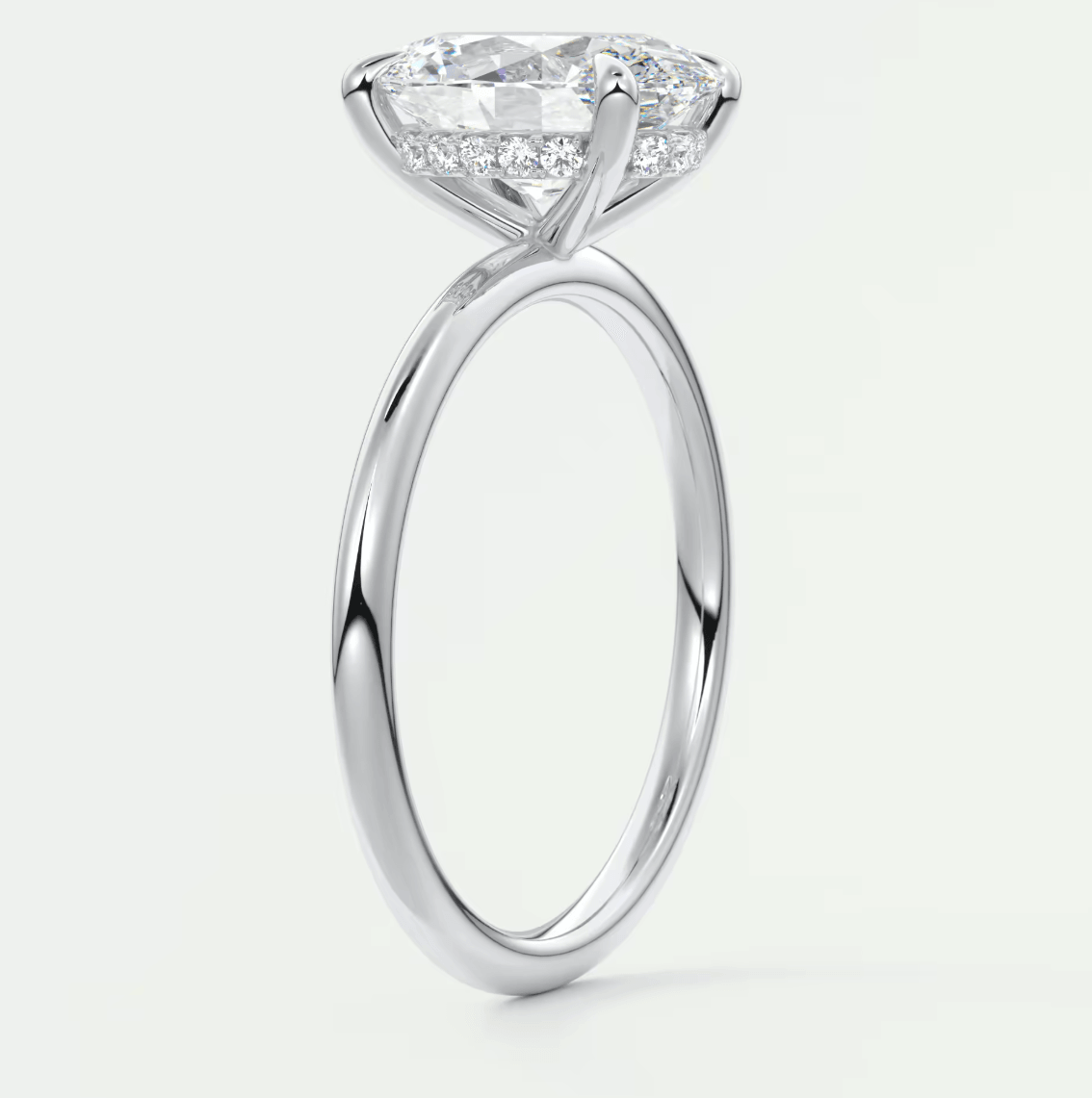 18-karat white gold engagement ring with a marquise-cut diamond and small diamonds on the band.