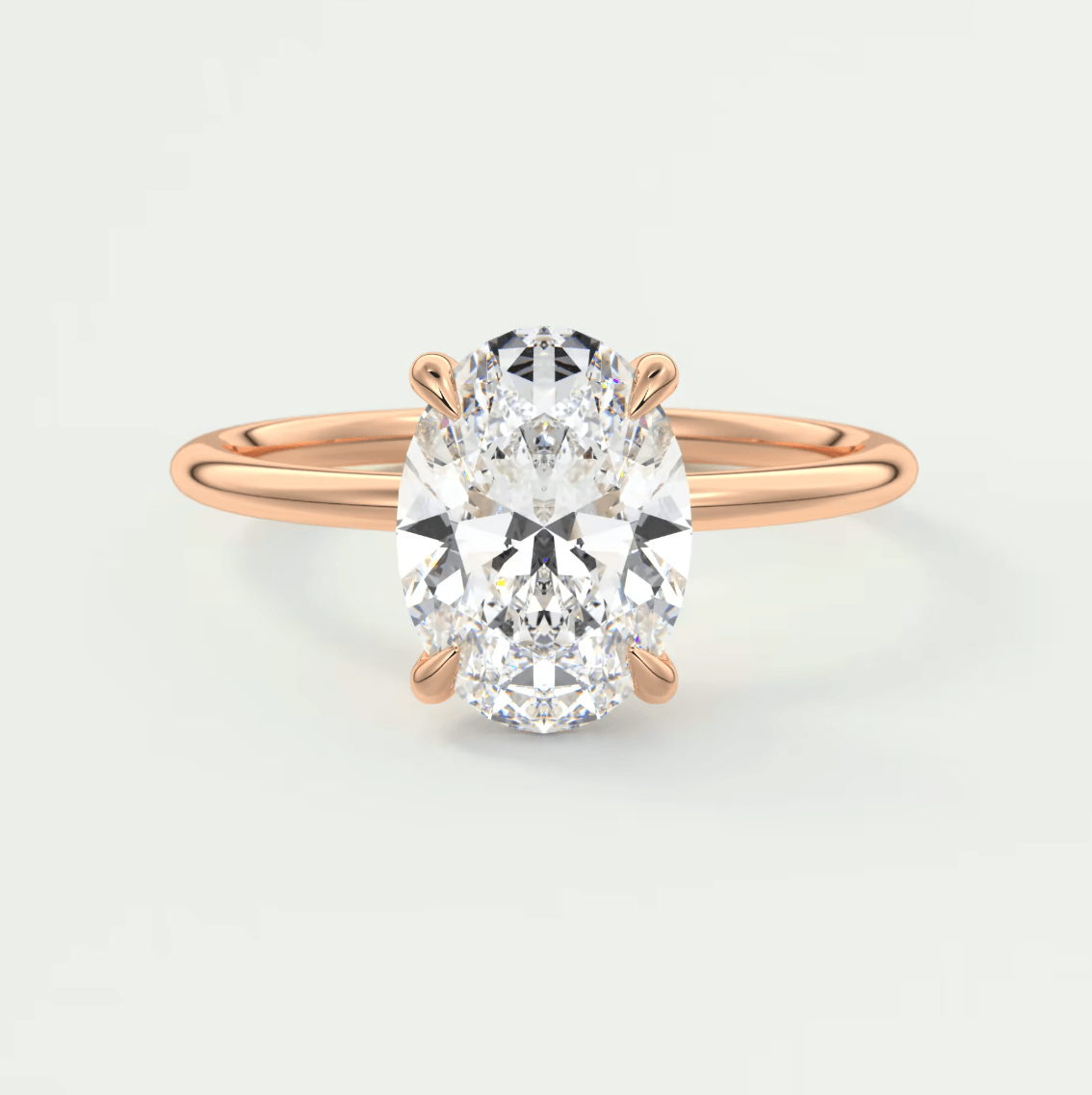 18-karat rose gold engagement ring with an oval diamond.