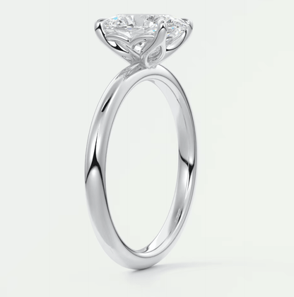 18-karat white gold solitaire diamond engagement ring with a cushion-cut center stone.
