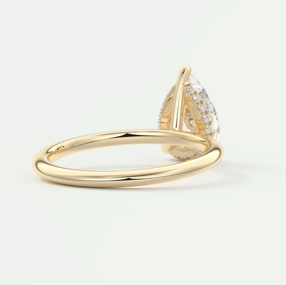 18k yellow gold pear-shaped diamond engagement ring with a halo of smaller diamonds.