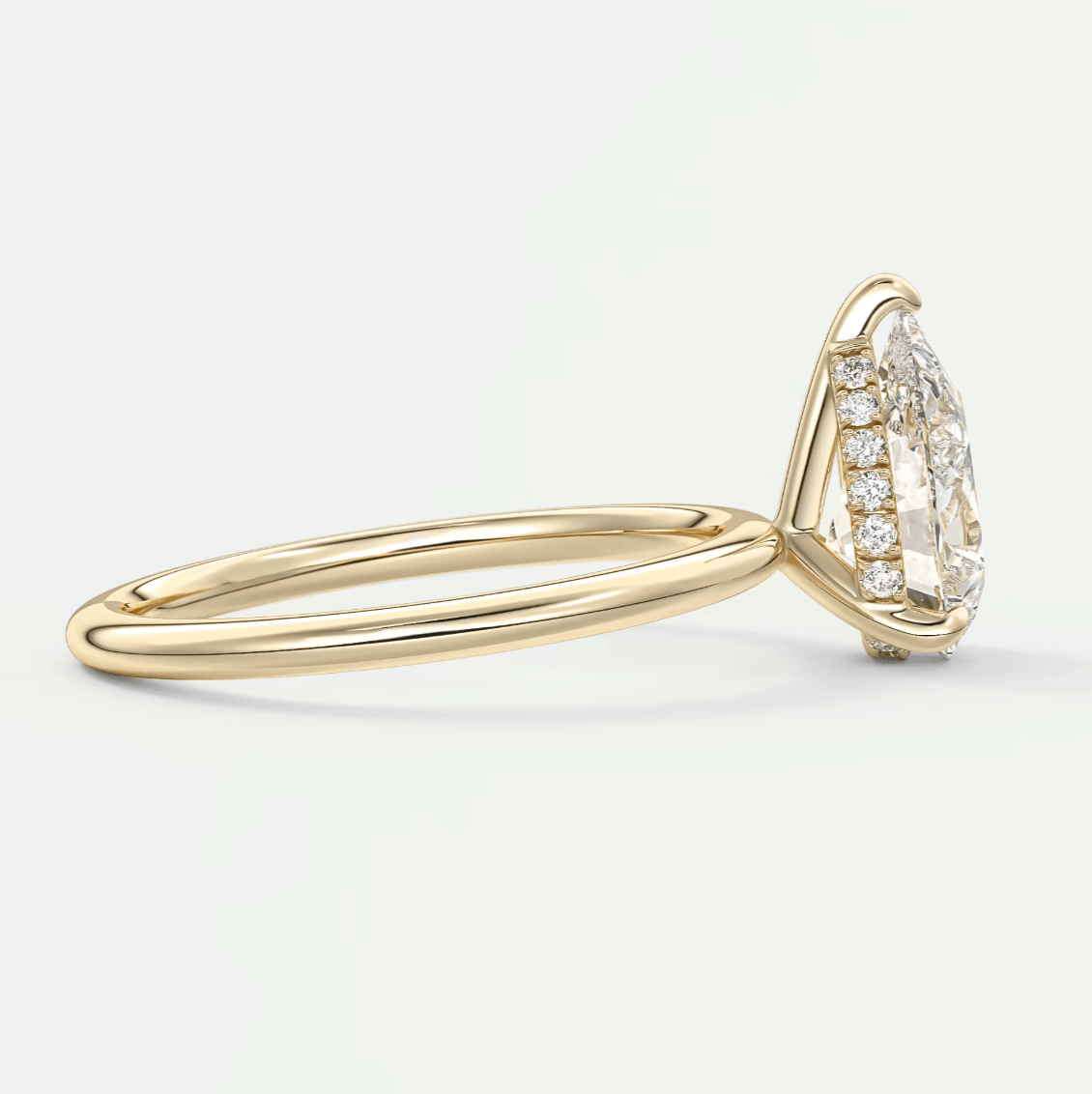 18k yellow gold diamond engagement ring with a marquise-cut center stone and pavé side stones.