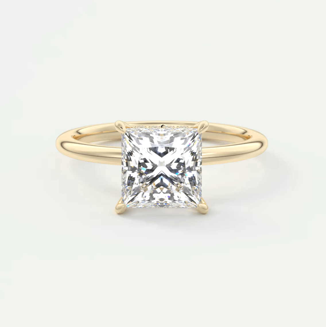 Princess cut diamond engagement ring with yellow gold band.