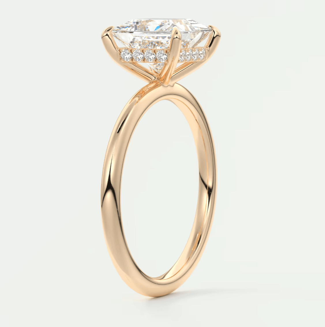 18-karat rose gold engagement ring with princess-cut diamond and pave-set diamonds on the band.