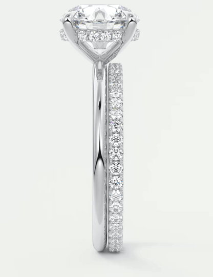 18-karat white gold diamond engagement ring with a round-cut center stone and pave-set diamonds on the band.