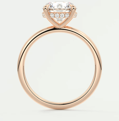 18-karat rose gold engagement ring with a cushion-cut diamond and small round diamonds set in the band.