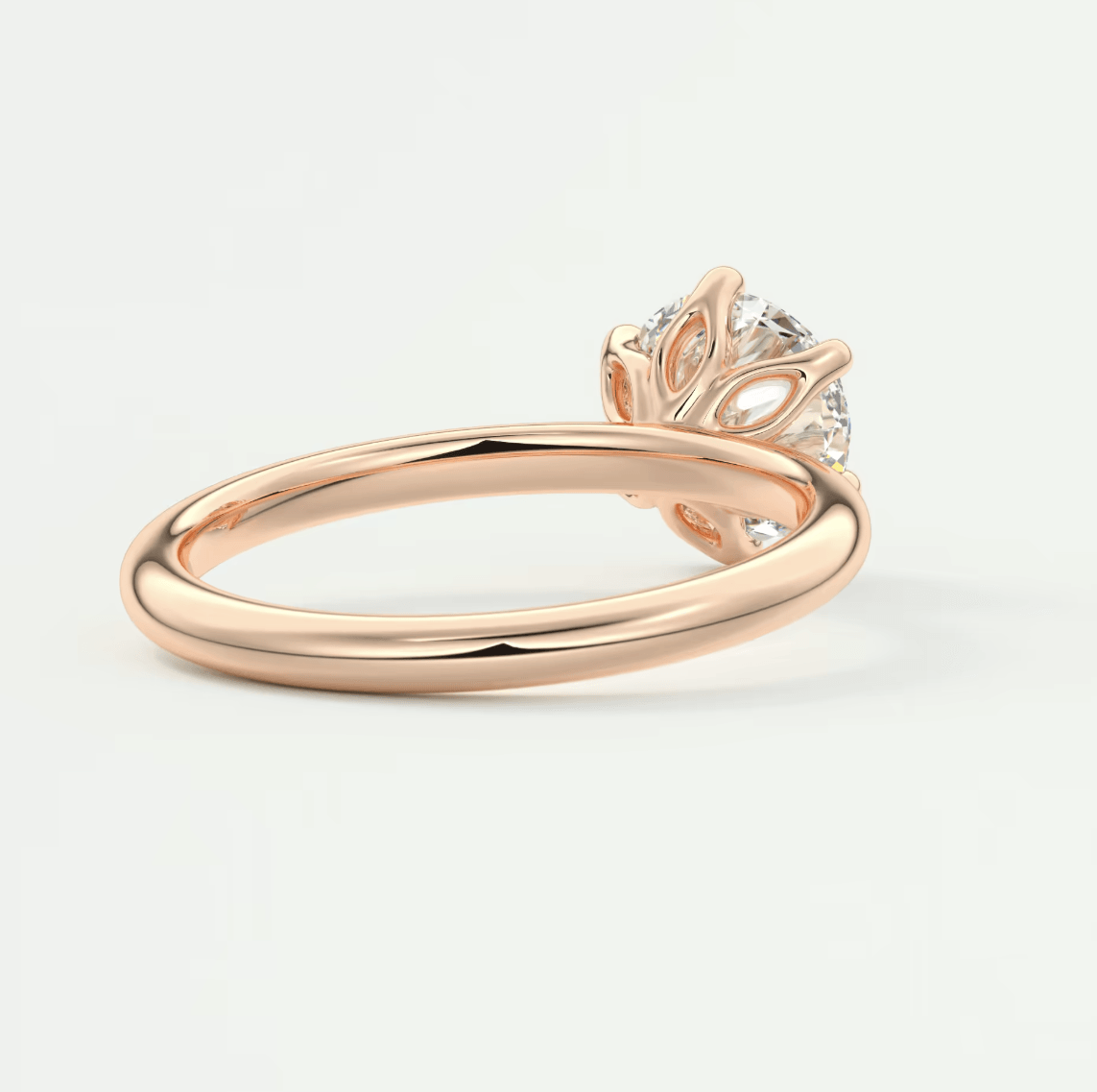 Rose gold engagement ring with leaf design and diamond center stone.