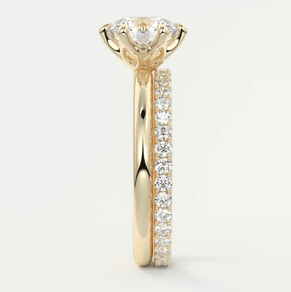 18k yellow gold diamond engagement ring with a round brilliant cut center stone and pavé set diamonds on the band.