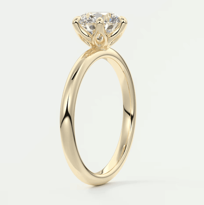 18-karat yellow gold solitaire engagement ring with a round diamond.