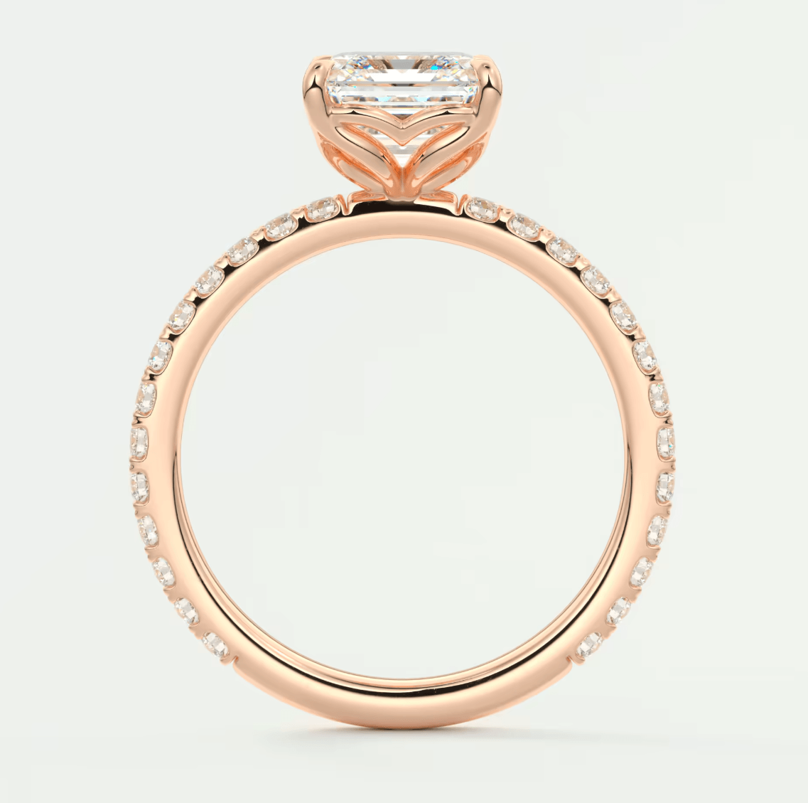 18k rose gold engagement ring with a princess cut diamond and pavé set diamonds on the band.