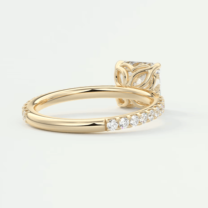 18k yellow gold engagement ring with a princess cut diamond and pavé side stones.