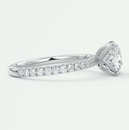 18k white gold diamond engagement ring with a cushion-cut center stone and pave set diamonds on the band.
