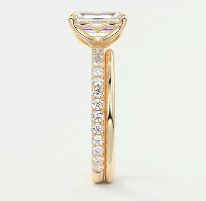 18k yellow gold engagement ring with an emerald-cut diamond and pavé set diamonds on the band.