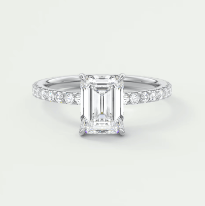 18k white gold emerald cut diamond engagement ring with a pavé band.
