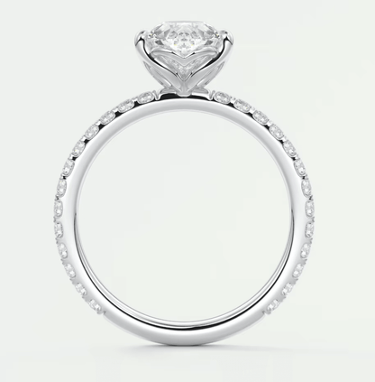 18k white gold engagement ring with a round diamond center and pavé set diamonds on the band.