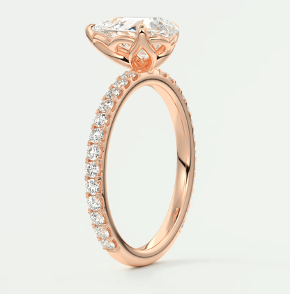 Rose gold engagement ring with a large central diamond and smaller diamonds along the band, featuring an intricate floral design.