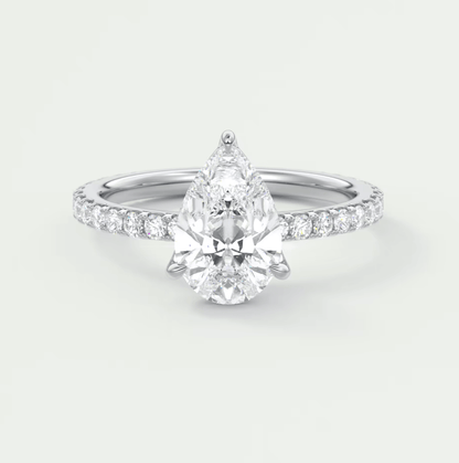 Pear-shaped diamond engagement ring with white gold band and pavé diamonds on the shoulders.
