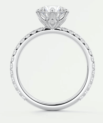 18-karat white gold engagement ring with a round diamond center and pavé set diamonds along the band.