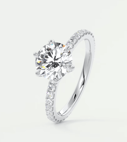 18k white gold diamond engagement ring with a round-cut center stone and pave-set diamonds on the band.