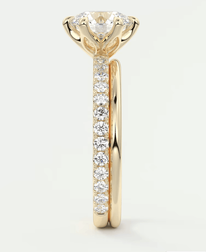 18-karat gold diamond engagement ring with a round-cut center stone and channel-set side diamonds.