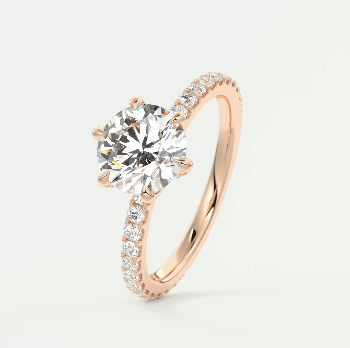 18-karat rose gold engagement ring with a round diamond center and pave-set diamonds on the band.