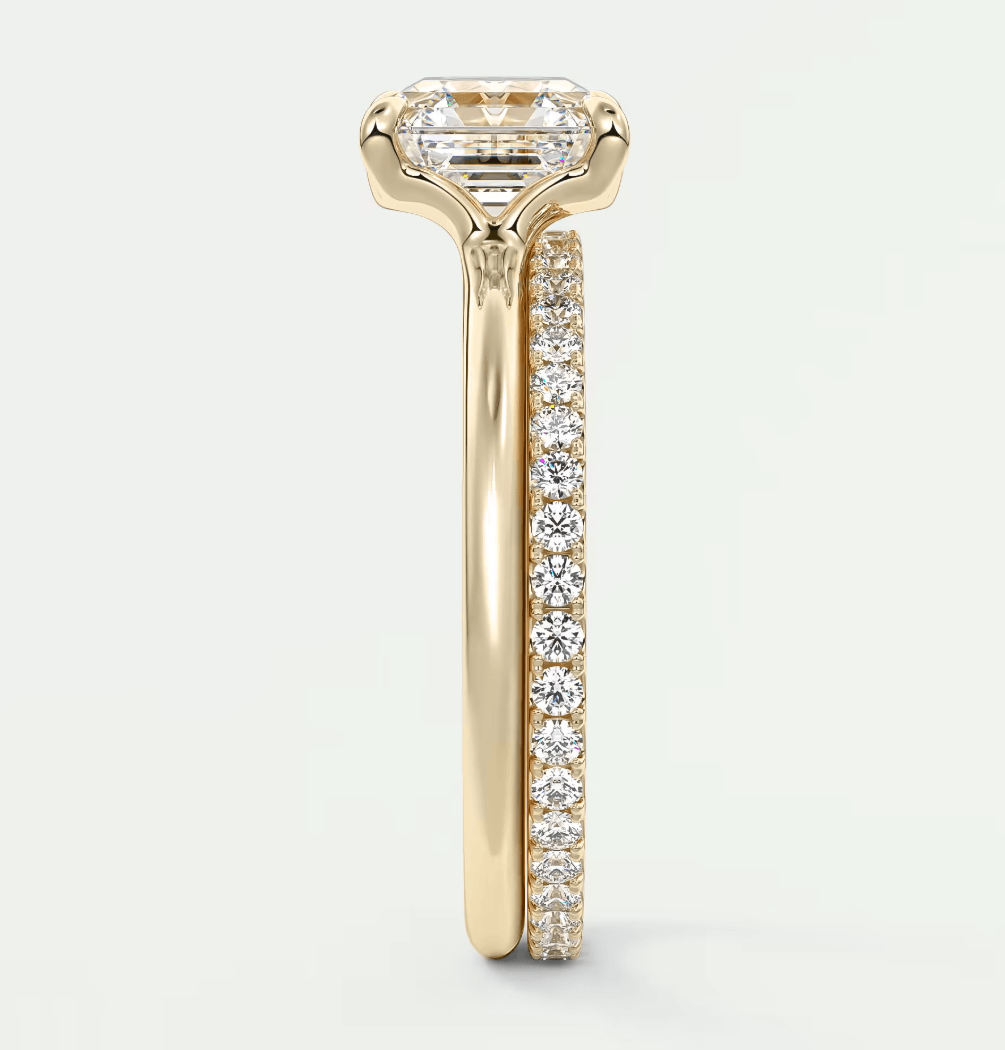 18k yellow gold engagement ring with emerald cut diamond center stone and pave set diamonds on band.