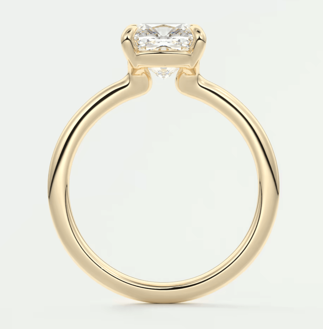 Gold princess cut diamond engagement ring with a solitaire setting.