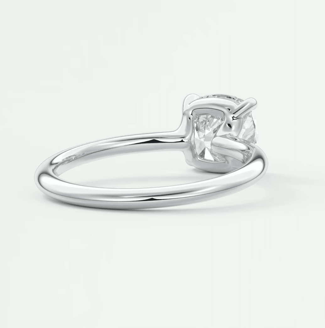 White gold solitaire diamond engagement ring with a cushion-cut gemstone.