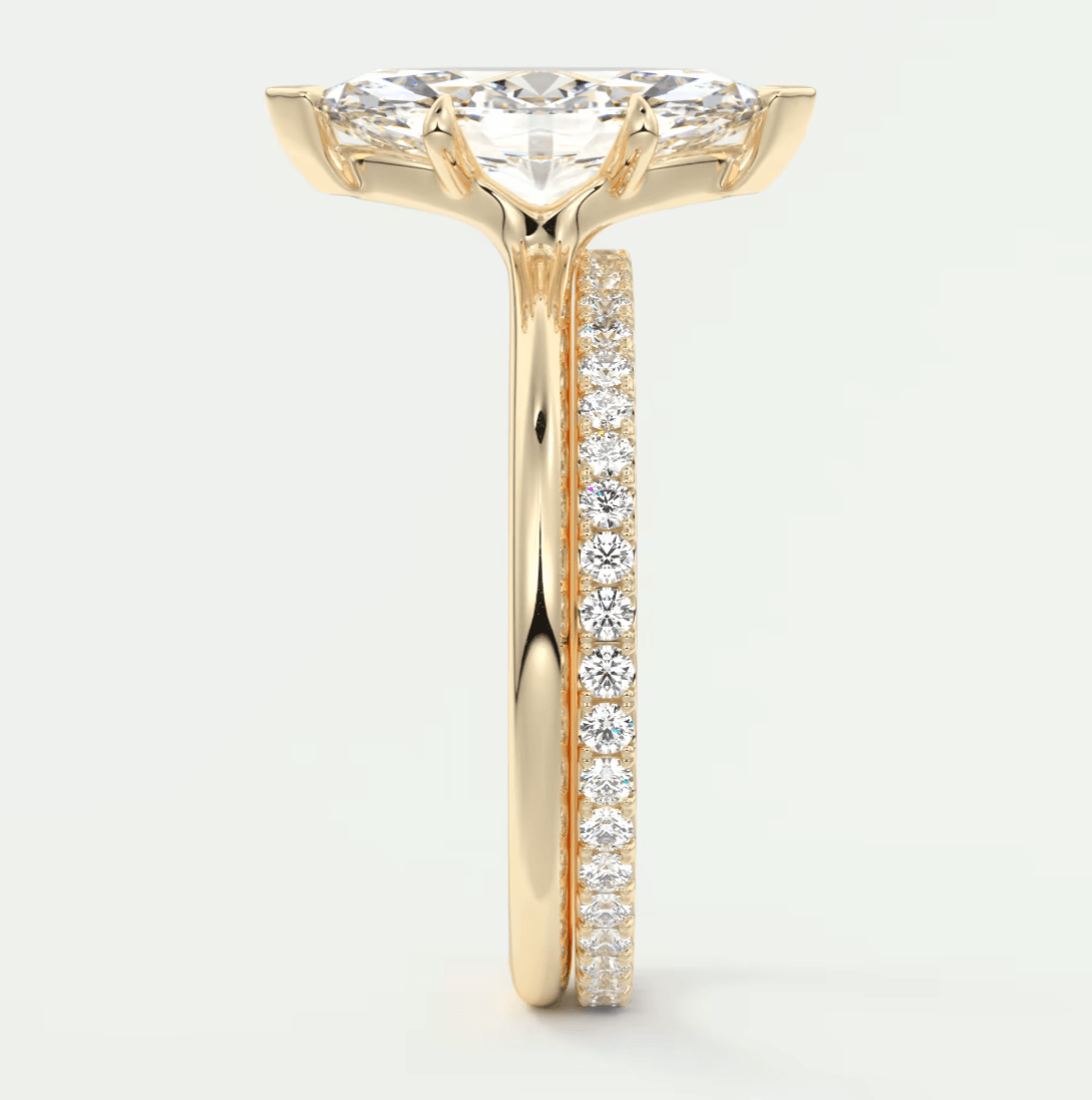 18k yellow gold diamond engagement ring with a marquise-cut center stone and pave-set diamonds on the band.
