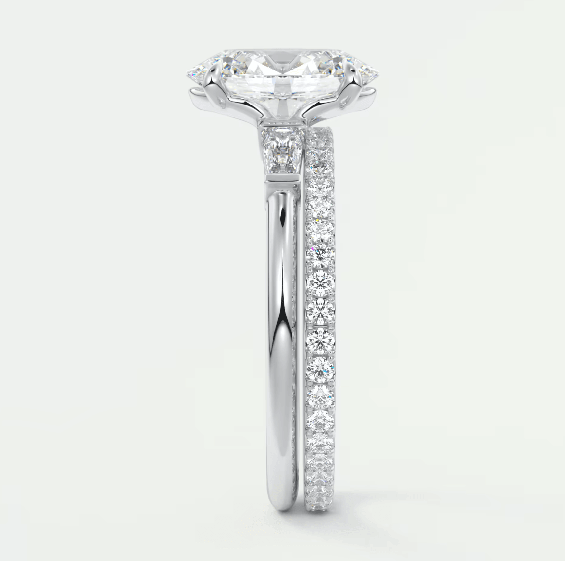 18k white gold engagement ring with a cushion-cut diamond and pavé side stones.