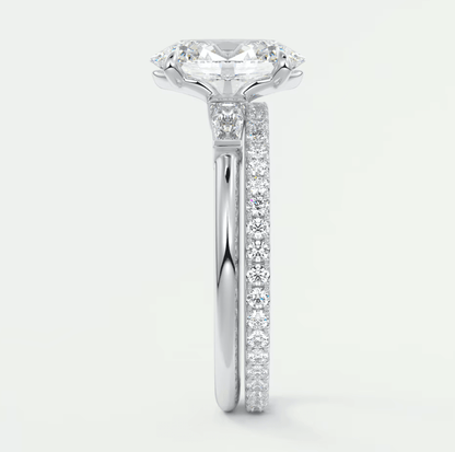 18k white gold engagement ring with a cushion-cut diamond and pavé side stones.