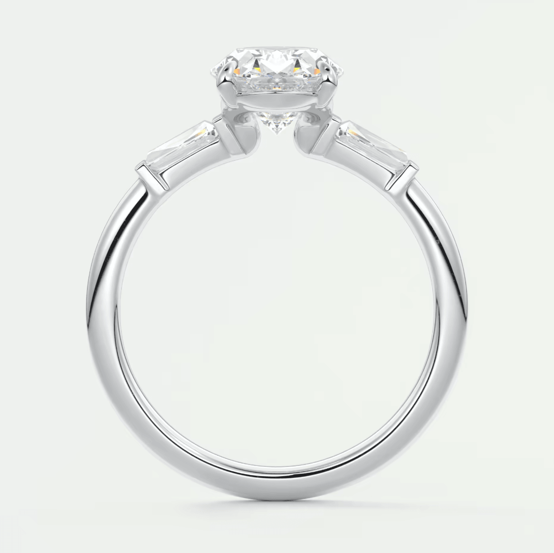 White gold engagement ring with a round diamond center and baguette side stones.