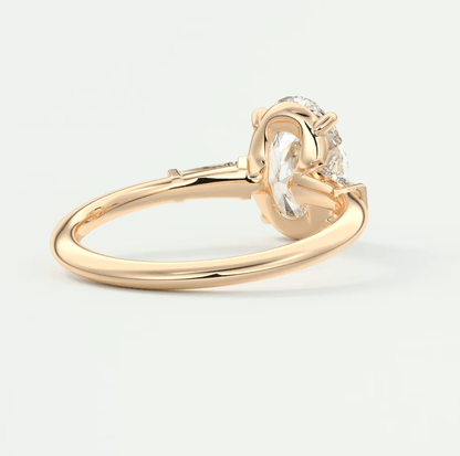 18-karat gold engagement ring with a round diamond and two smaller diamonds on each side, featuring an elegant solitaire design.